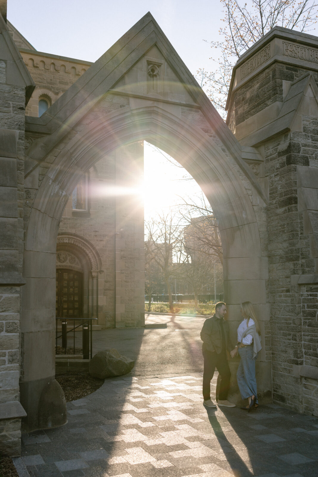 Intimate engagement portrait with soft light and historic architecture at University of Toronto