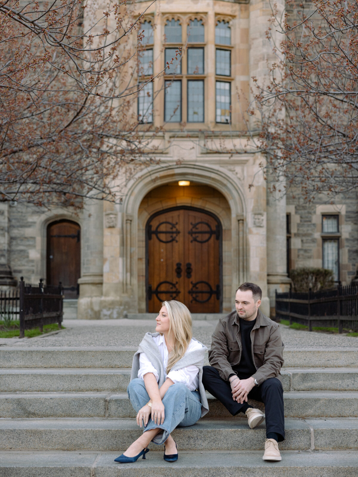 Couple embracing in front of gothic architecture at University of Toronto in Toronto Ontario
