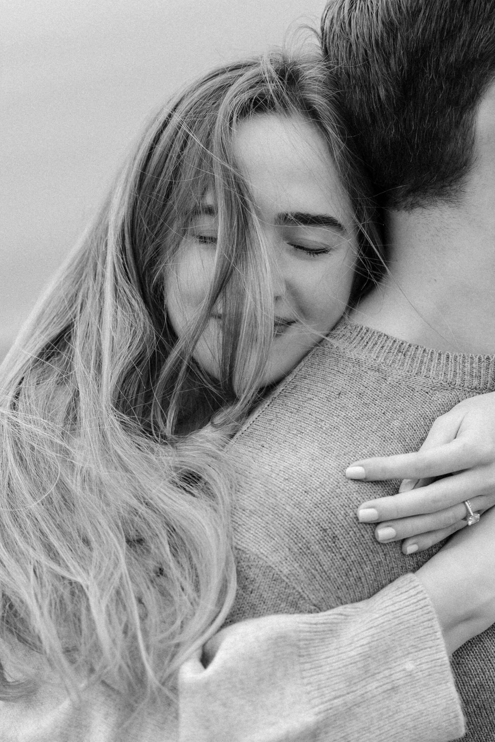 romantic engagement photos of a couple by Lake Ontario with soft light and natural movement