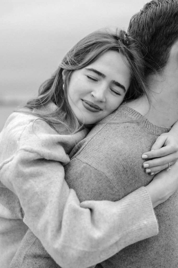 romantic engagement photos of a couple by Lake Ontario with soft light and natural movement
