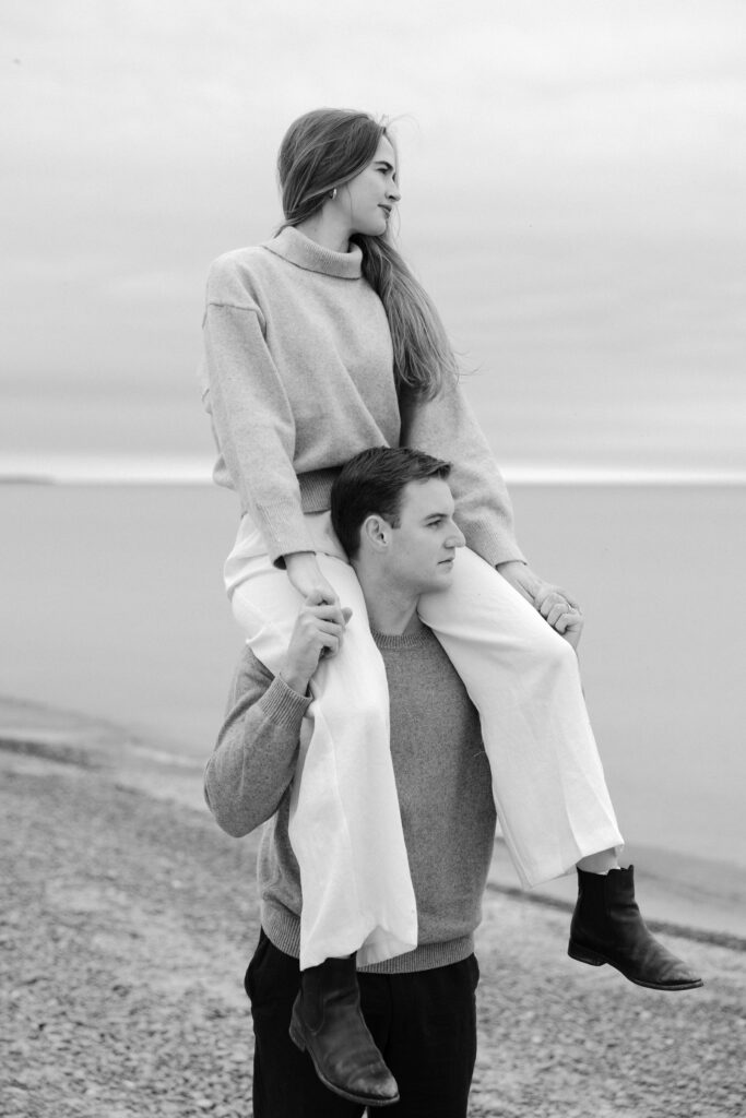 romantic engagement photos of a couple by Lake Ontario with soft light and natural movement