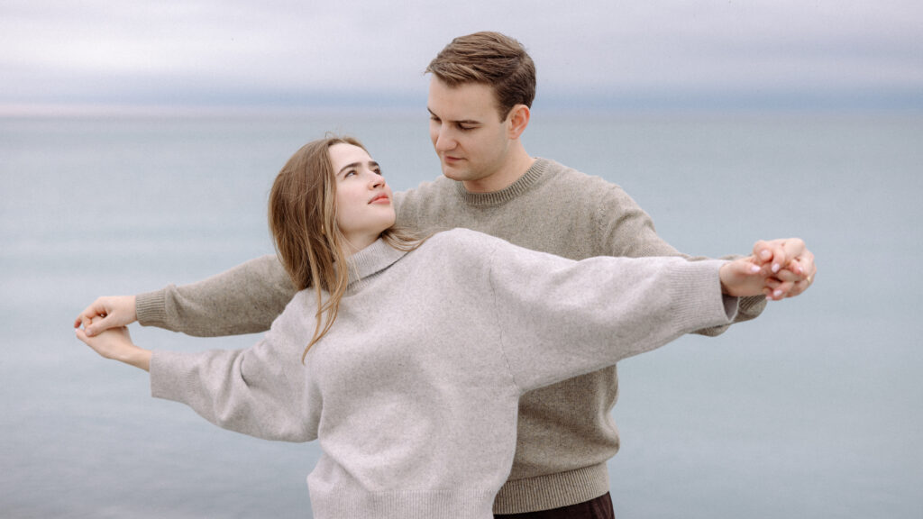 romantic engagement photos of a couple by Lake Ontario with soft light and natural movement