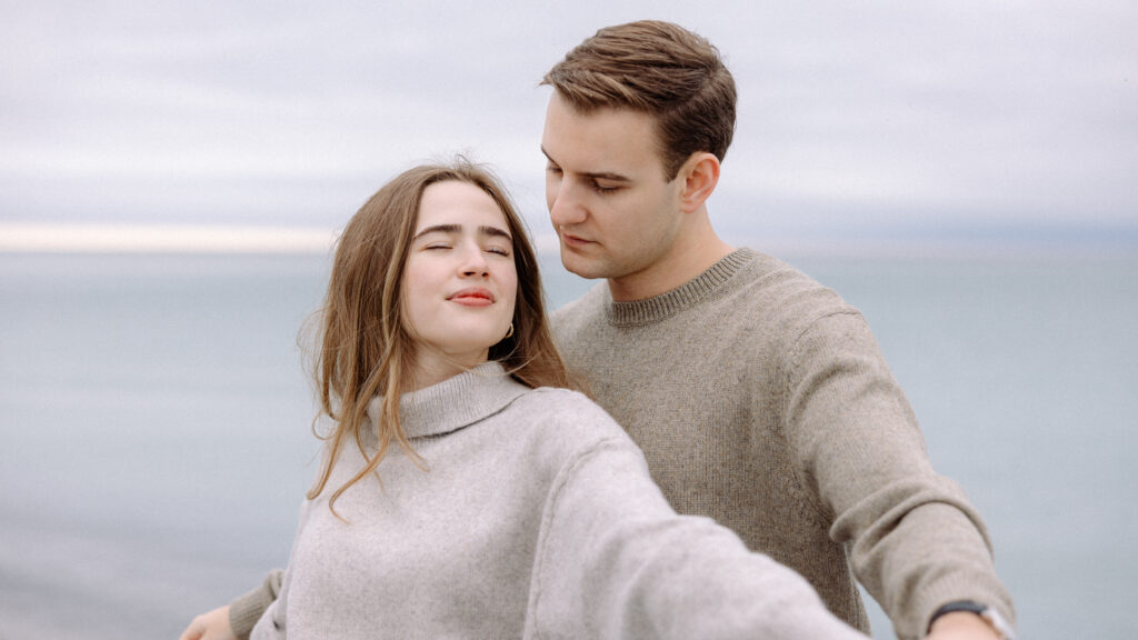 romantic engagement photos of a couple by Lake Ontario with soft light and natural movement