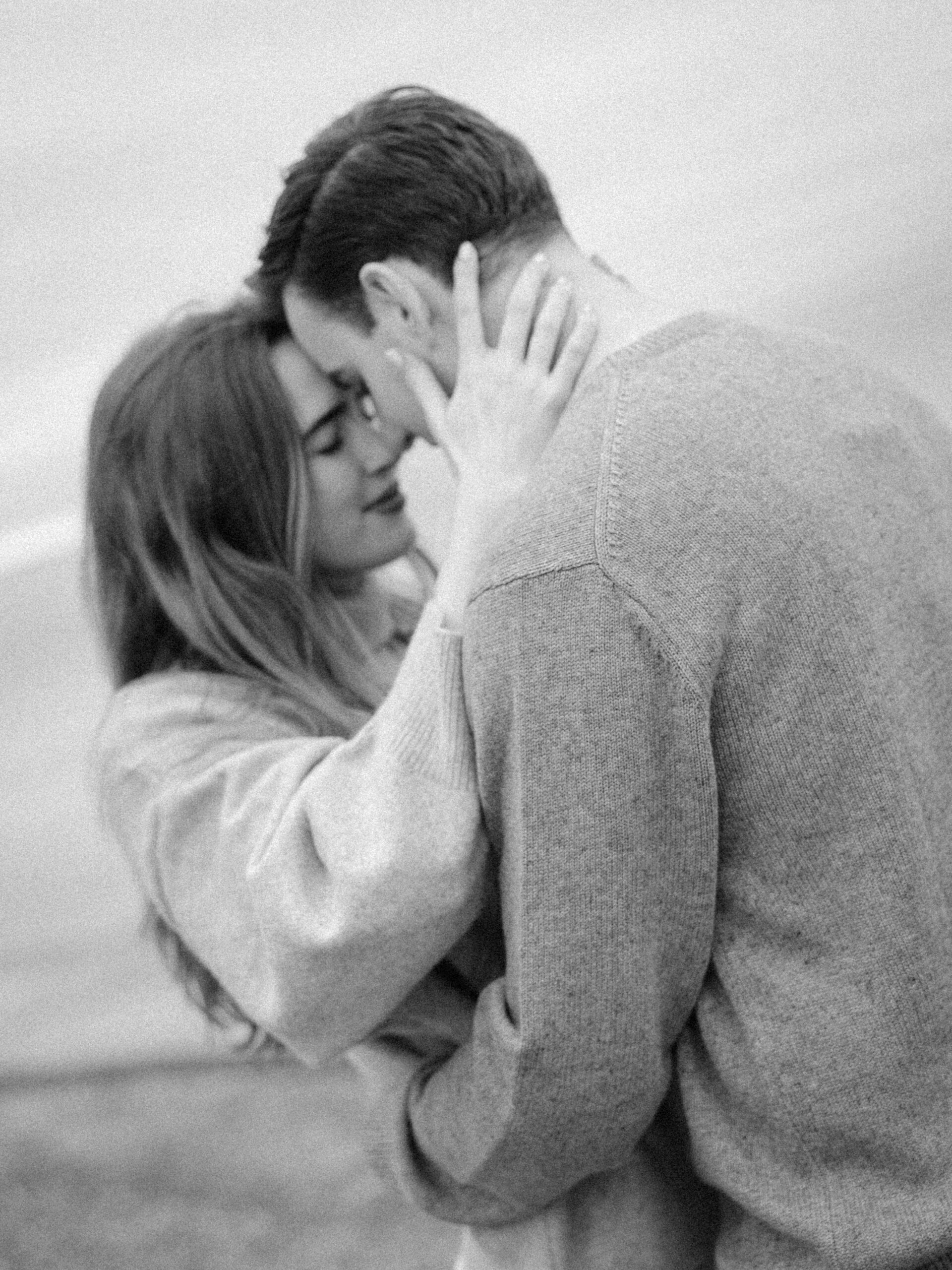 romantic engagement photos of a couple by Lake Ontario with soft light and natural movement