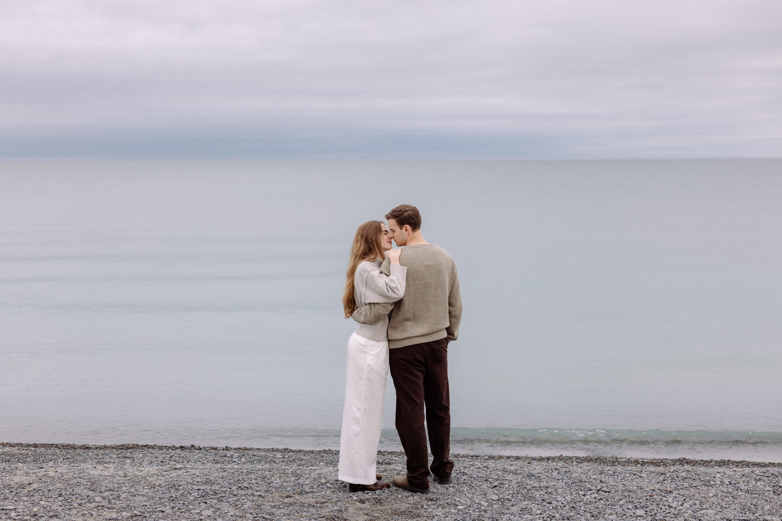 engaged couple walking along the beach with natural movement during a candid engagement session